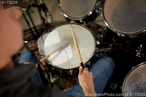 Image of man playing drums at concert or music studio