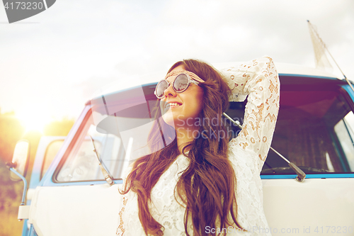 Image of smiling young hippie woman in minivan car