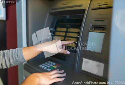 Image of close up of hands choosing option on atm machine