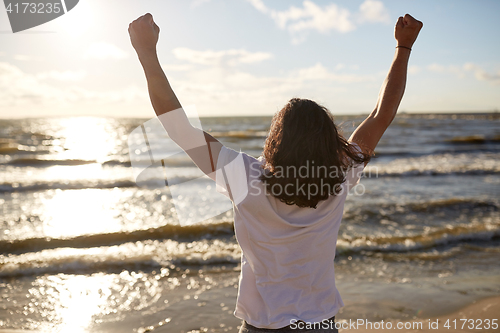 Image of man with rised fist on beach