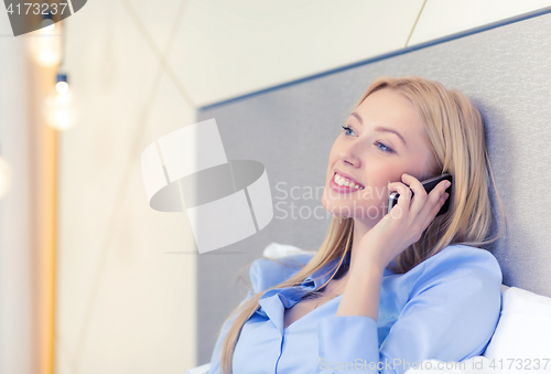 Image of happy businesswoman with smartphone in hotel room