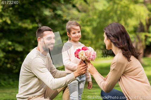 Image of happy family with flowers in summer park