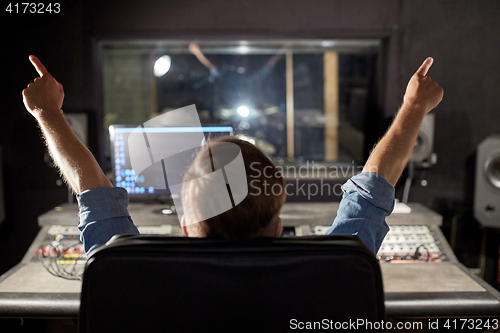 Image of man at mixing console in music recording studio