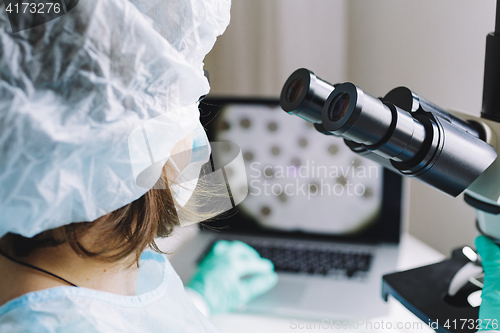 Image of Female scientist working on laptop in laboratory.