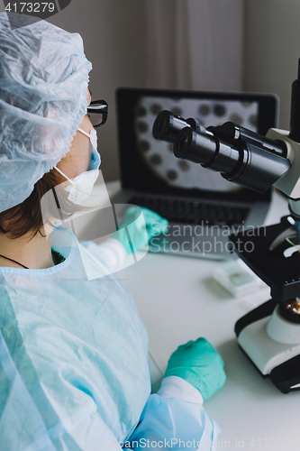 Image of Female scientist working on laptop in laboratory.