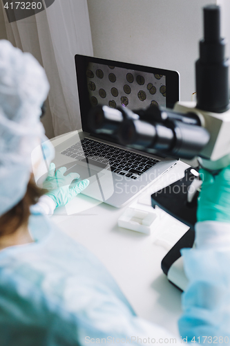 Image of Female scientist working on laptop in laboratory.