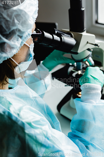 Image of Scientist working in laboratory with microscope