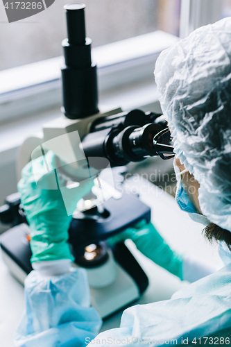 Image of Scientist working in laboratory with microscope