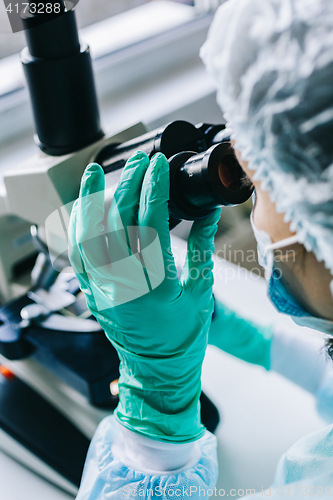 Image of Scientist working in laboratory with microscope