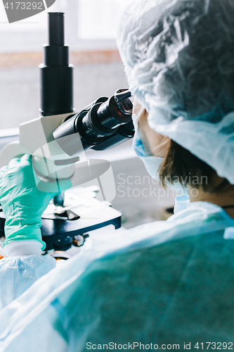 Image of Scientist working in laboratory with microscope