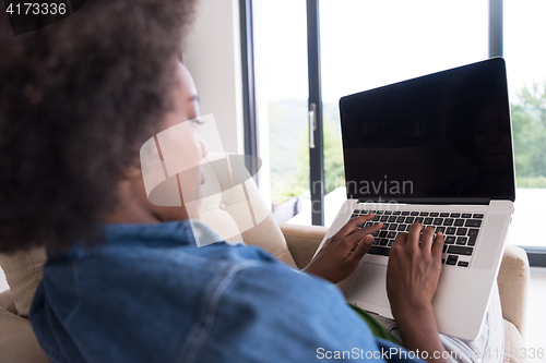 Image of African American women at home in the chair using a laptop