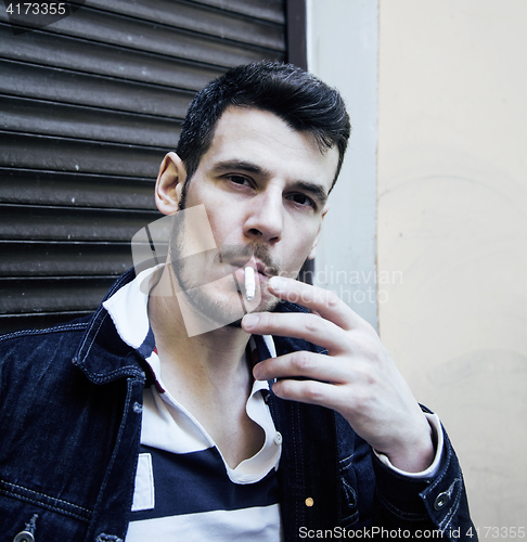 Image of middle age man smoking cigarette on bacyjard, stylish tough guy,