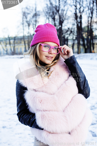 Image of young pretty teenage hipster girl outdoor in winter snow park having fun drinking coffee, warming up happy smiling, lifestyle people concept