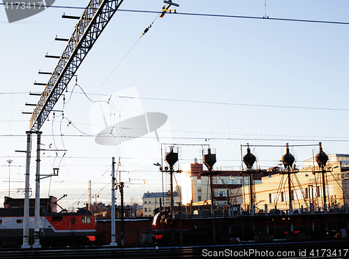 Image of landscape with railway with trains, lot of steel rafters at sunset