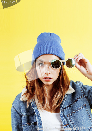 Image of young pretty teenage woman emotional posing on yellow background, fashion lifestyle people concept 