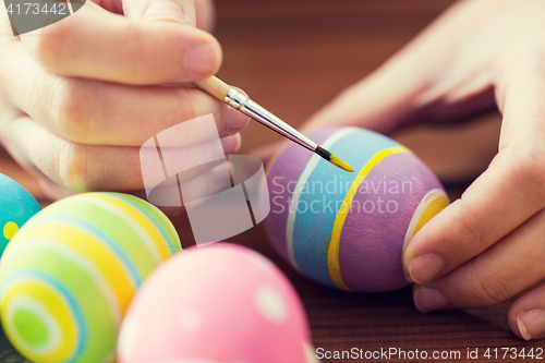 Image of close up of woman hands coloring easter eggs