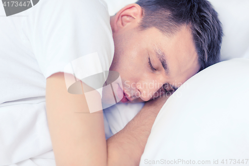 Image of handsome man sleeping in bed