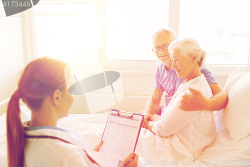 Image of senior woman and doctor with clipboard at hospital