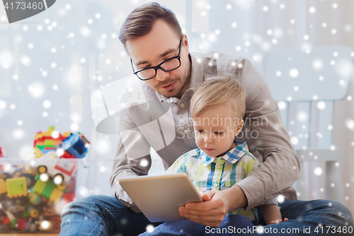 Image of father and son with tablet pc playing at home