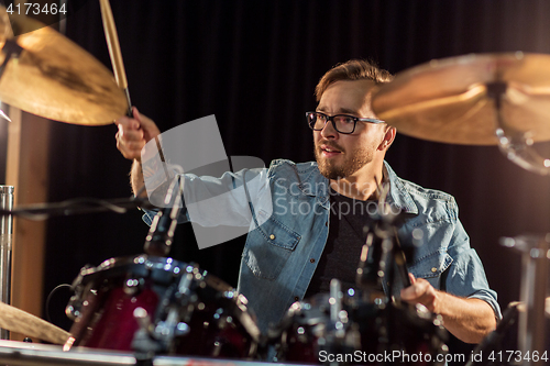Image of male musician playing drums and cymbals at concert