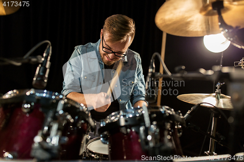 Image of male musician playing drums and cymbals at concert