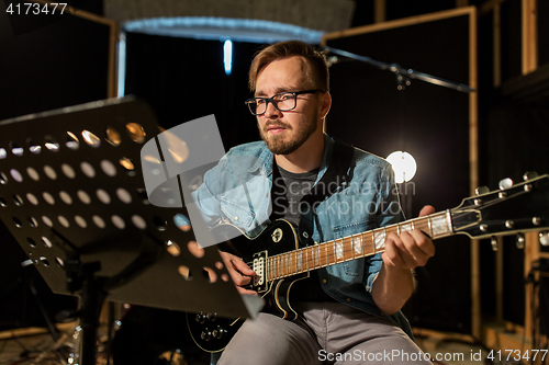 Image of man playing guitar at studio rehearsal