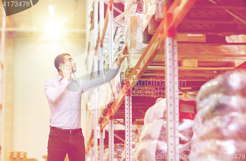 Image of serious man calling on smartphone at warehouse