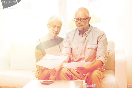 Image of senior couple with papers and calculator at home