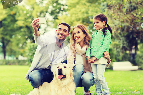 Image of happy family with dog taking selfie by smartphone