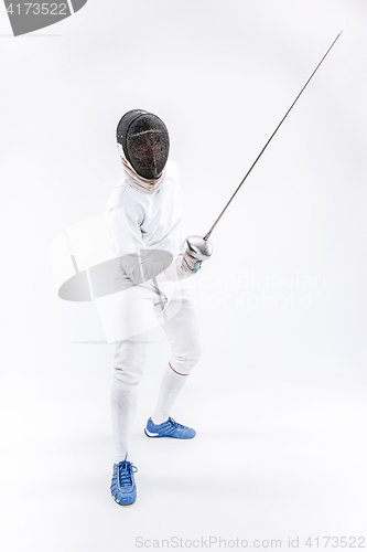 Image of Man wearing fencing suit practicing with sword against gray