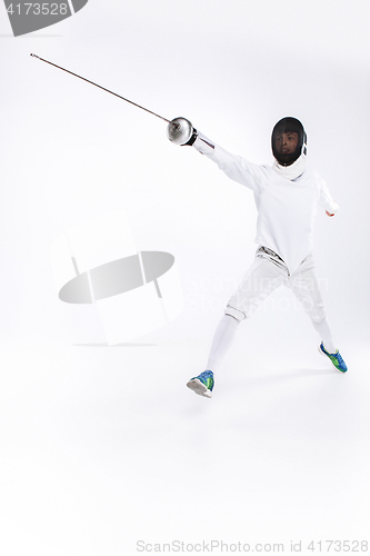 Image of Man wearing fencing suit practicing with sword against gray