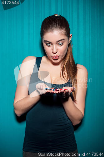 Image of Young girl holding poker chips on blue background