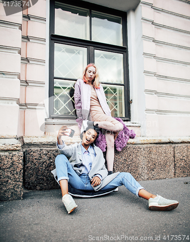 Image of Two teenage girls infront of university building smiling, having