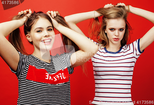 Image of two best friends teenage girls together having fun, posing emotional on red background, besties happy smiling, lifestyle people concept 