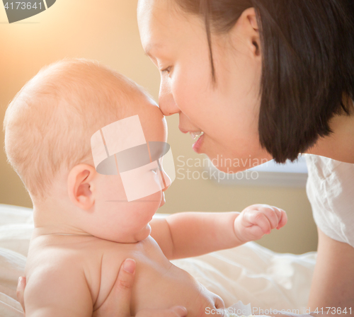 Image of Mixed Race Chinese and Caucasian Baby Boy Laying In Bed with His