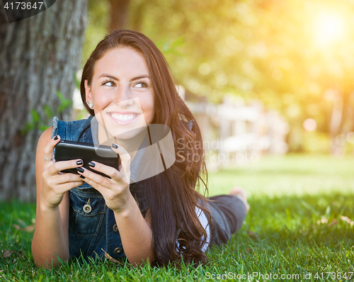 Image of Mixed Race Young Female Texting on Cell Phone Outside In The Gra