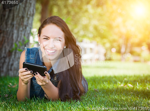 Image of Mixed Race Young Female Texting on Cell Phone Outside In The Gra