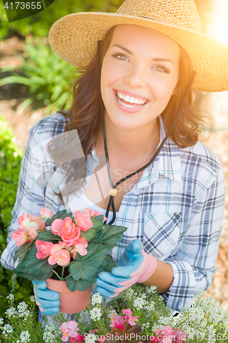 Image of Young Adult Woman Wearing Hat and Gloves Gardening Outdoors