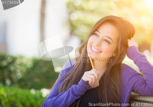 Image of Pensive Mixed Race Female Student with Pencil on Campus