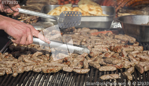 Image of Grilling cevaps or kebabs on a grill at the street market