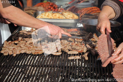 Image of Grilling cevaps or kebabs on a grill at the street market