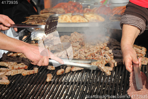 Image of Grilling cevaps or kebabs on a grill at the street market