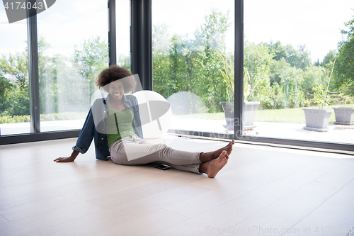 Image of african american  woman  sitting near window