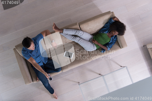 Image of multiethnic couple relaxes in the living room top view