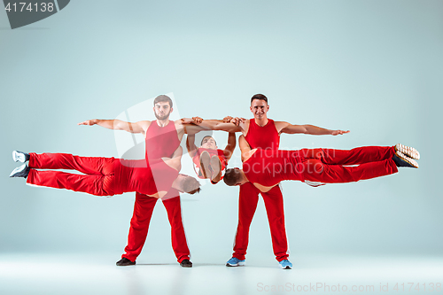 Image of The group of gymnastic acrobatic caucasian men on balance pose