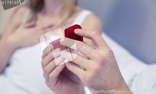 Image of close up of hands holding little red gift box