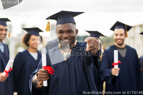 Image of happy student with diploma pointing finger at you