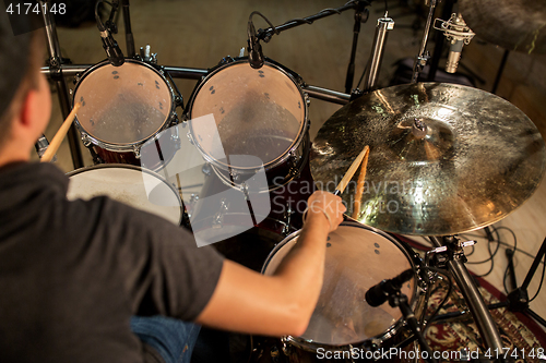 Image of male musician playing drums and cymbals at concert