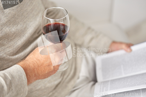 Image of close up of senior man with wine glass and book