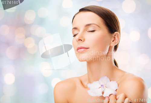 Image of beautiful young woman with orchid flower